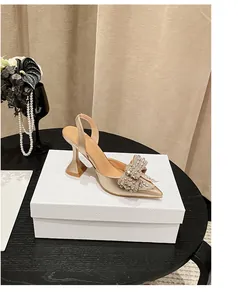 Elegante goldene Slingback-Pumps mit Strassschleife und modischem Kelchabsatz.