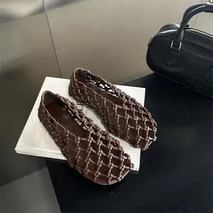 Detail of intricate dark brown hollow woven design on breathable French style flat sandals.