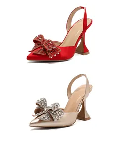 Elegante spitzzulaufende High Heels mit Strass-Schleife in glänzendem Rot und Gold