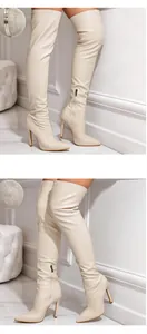 Detail view of beige crocodile embossed thigh high boots with stiletto high heels.