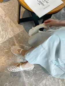 Close-up of white handmade woven Mary Jane flats showing intricate breathable pattern