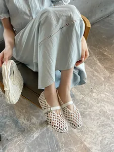 Close-up detail of breathable white hand-woven Mary Jane flat shoes with buckle strap