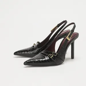 Salones slingback negros de punta con textura de cocodrilo y hebillas doradas.