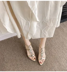 Close-up of elegant pointed toe sandals with sparkling rhinestone embellishments and gold finish.