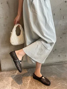 Close-up view of black hand-woven breathable Mary Jane shoes with elegant buckle strap detail