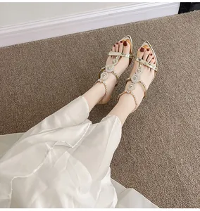 Elegant pointed-toe high heel sandals with sparkling rhinestones, shown on model with dress.