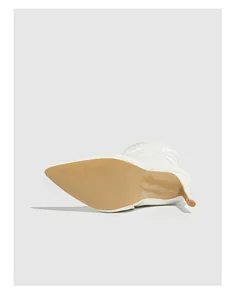 Detailed view of the smooth sole and stiletto heel of white patent leather boots