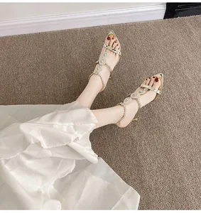 Detailed view of elegant gold stiletto sandals with sparkling rhinestone T-strap.