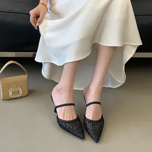 Elegant detail of black woven hollow pointed-toe high heel mules with a thin strap