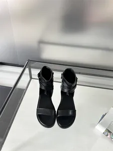 Top-down view of black flat Roman sandals featuring buckled ankle straps and soft soles