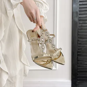 Elegant gold pointed toe stiletto sandals with sparkling rhinestone straps.