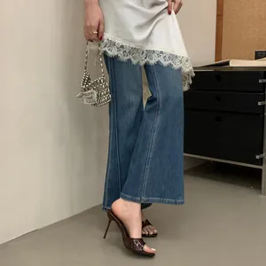 Close-up of elegant brown stiletto high heel mule sandals with 9cm heel and jeans