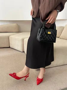 Side view of elegant red patent leather pointed-toe heels with buckle detail