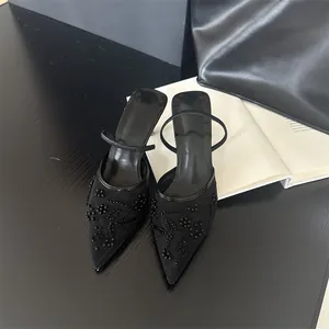 Detailed top view of elegant black pointed-toe mesh mules with intricate bead embroidery