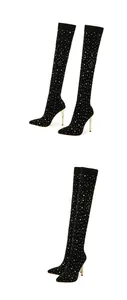 Elegant black over-the-knee boots with rhinestone embellishments and gold stiletto heels