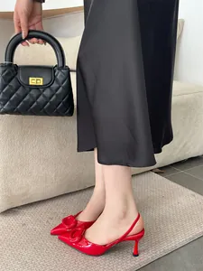 Detail view of stylish red pointed toe slingback high heels featuring a decorative buckle