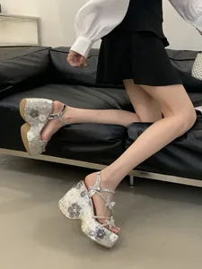 Detailed side view of silver platform wedge sandals with sequin flower patterns