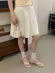 Dettaglio dei sandali bianchi infradito con tacco gattino in un elegante stile minimalista
