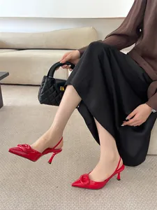 Macro view of red patent leather pointed-toe slingback heels with elegant buckle detail