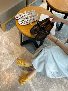 Hand-woven Mary Jane shoes in white, black, and yellow displayed in a cozy setting.