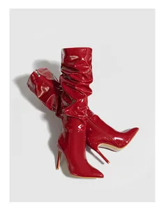 Elegant red slouched patent leather stiletto boots featuring a sharp pointed toe design
