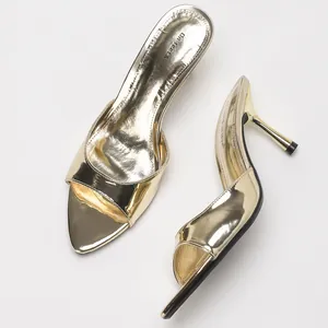 Eleganti sandali sabot dorati metallizzati con tacco a spillo dal design minimalista.