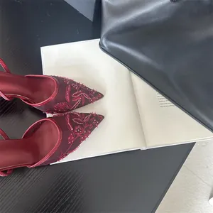 Close-up view of burgundy mesh heels with intricate floral embroidery and beads.