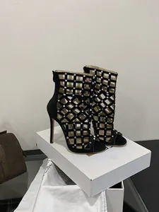 Detailed close-up of black cage stiletto heels with silver studs and back zipper
