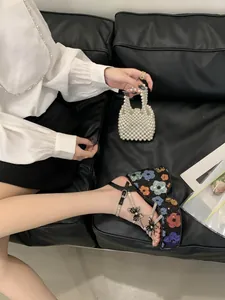 Close-up of floral sequin platform sandals with butterfly charms and rhinestone straps