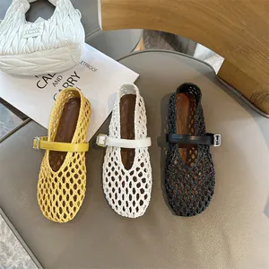 Detail of woven hollow out Mary Jane flats in yellow, white, and black colors.