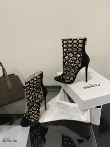 Detailed view of black stiletto sandals with silver studs and cage cutouts