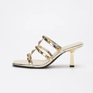 Elegante goldene Pantoletten mit Metallic-Nieten und quadratischer Zehenpartie