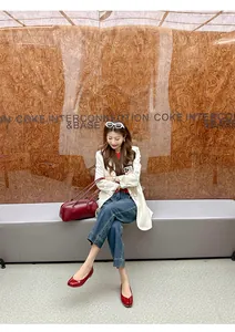 Red split-toe Tabi flats stylishly worn with casual denim in a lifestyle street setting