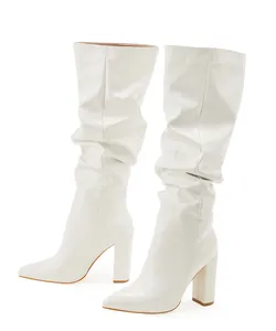 Side view of white slouched mid-calf boots with pointed toe and block heel