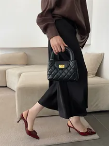 Close-up of burgundy pointed-toe slingback heels with elegant square buckle detail