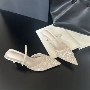 Elegant pointed-toe mule heels with intricate white floral embroidery and mesh detail