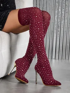 Detail of burgundy rhinestone over-the-knee boots with pointed toe and stiletto heel.