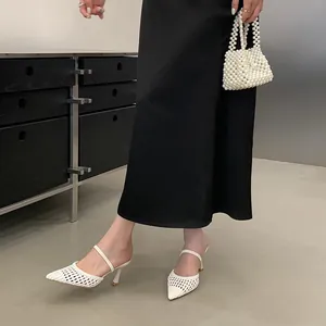 Detailed view of elegant white woven pointed toe high heel mules with hollow out design