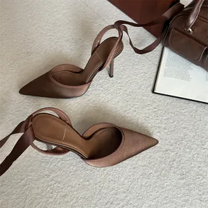 Vista detallada de tacones marrones de punta con cintas al tobillo de estilo vintage