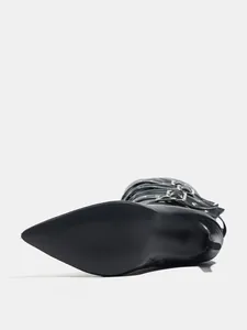 Detailed view of black punk style high-heeled boots with metallic buckles and pointed toe.