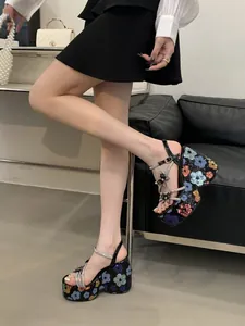 Close-up detail of women's floral sequin platform wedge sandals with butterfly charms