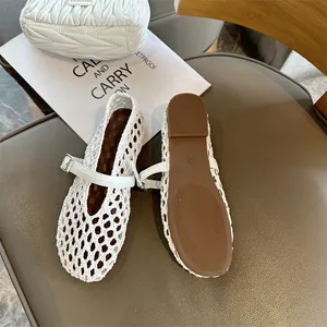 Detailed view of white hand-knitted hollow Mary Jane flats with buckle strap