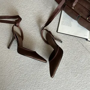 Elegantes tacones de satén marrón de punta con cintas en el tobillo y un aire vintage francés.