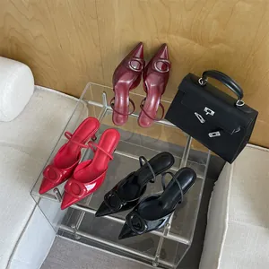 Macro view of pointed-toe patent pumps with tonal square buckles in multiple colors