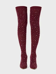 Close-up of burgundy over-the-knee boots with sparkling rhinestone embellishments