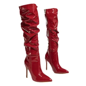 Red shiny patent leather slouchy high-heeled boots with pointed toe and stiletto heels