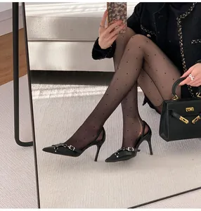 Vista detallada de elegantes tacones de aguja negros en punta con hebillas de metal