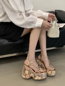 Close-up of rose gold platform wedge sandals with floral sequins and crystal butterfly details