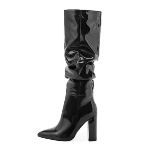 Side view of black patent leather mid-calf boots featuring slouchy design and block heel