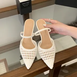 Elegant white woven pointed-toe high heel mules with slim strap on glass shelf